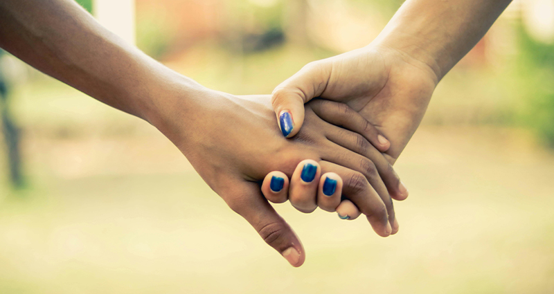 Stock photo of caring hand-holding.