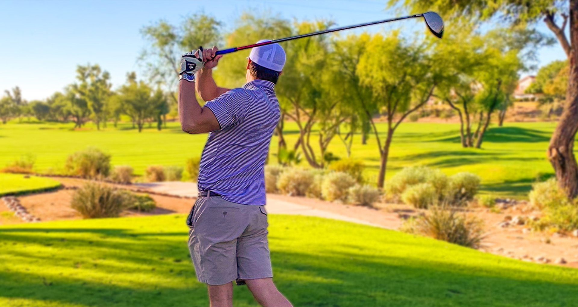 Photo from the 2021 Firetag Golf Tournament. A golfer is pictured mid-swing on the golf course.