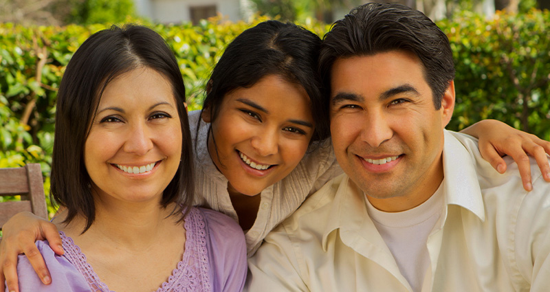 Stock photo of a hispanic family smiling at the camera. From Digitalskillet on Canva Pro.