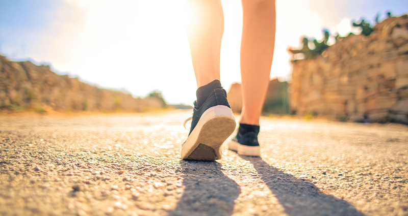 Stock photo of a person in tennis shoes taking a walk. From Andrea Piacquadio on Pexels.