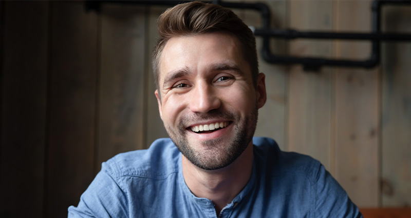 Stock photo of a man smiling at the camera. From aleksandrdavydovphotos on Canva Pro.