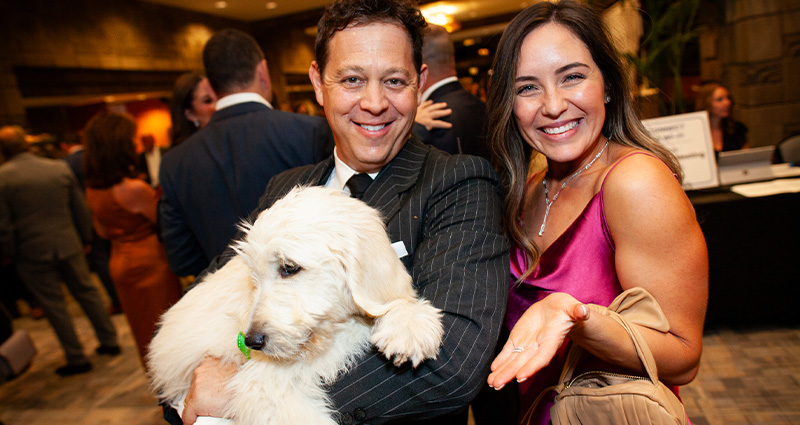 Photo of Jeff and Danielle Fields holding a goldendoodle puppy that was part of the 2023 Connections of Hope Gala live auction.