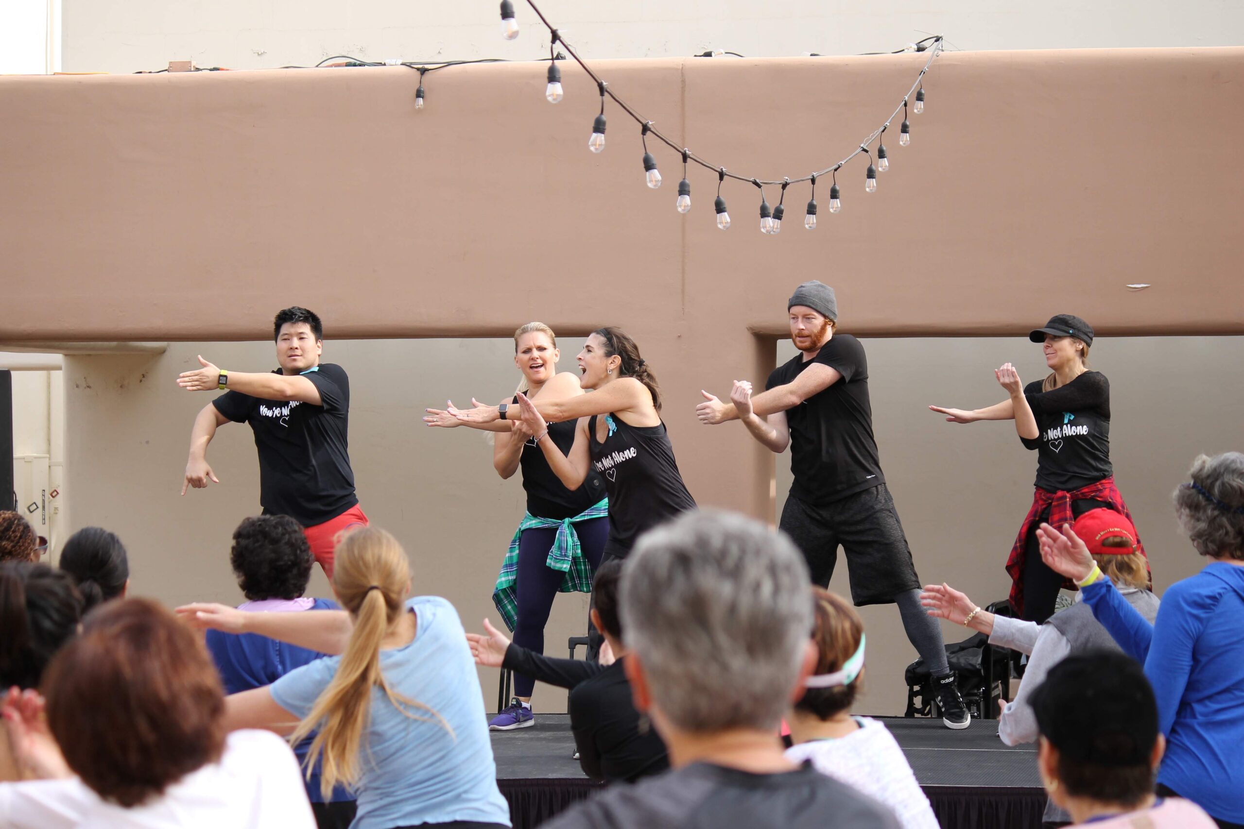Photo of a dance instructor leading a group of people at a Zumbathon fundraiser.